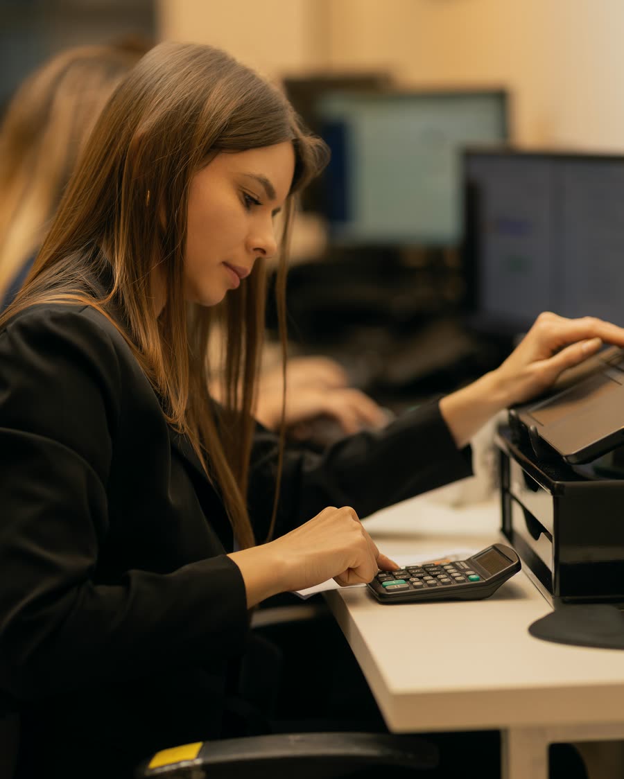 Colaboradora usa uma calculadora na estação de trabalho, em 2025.