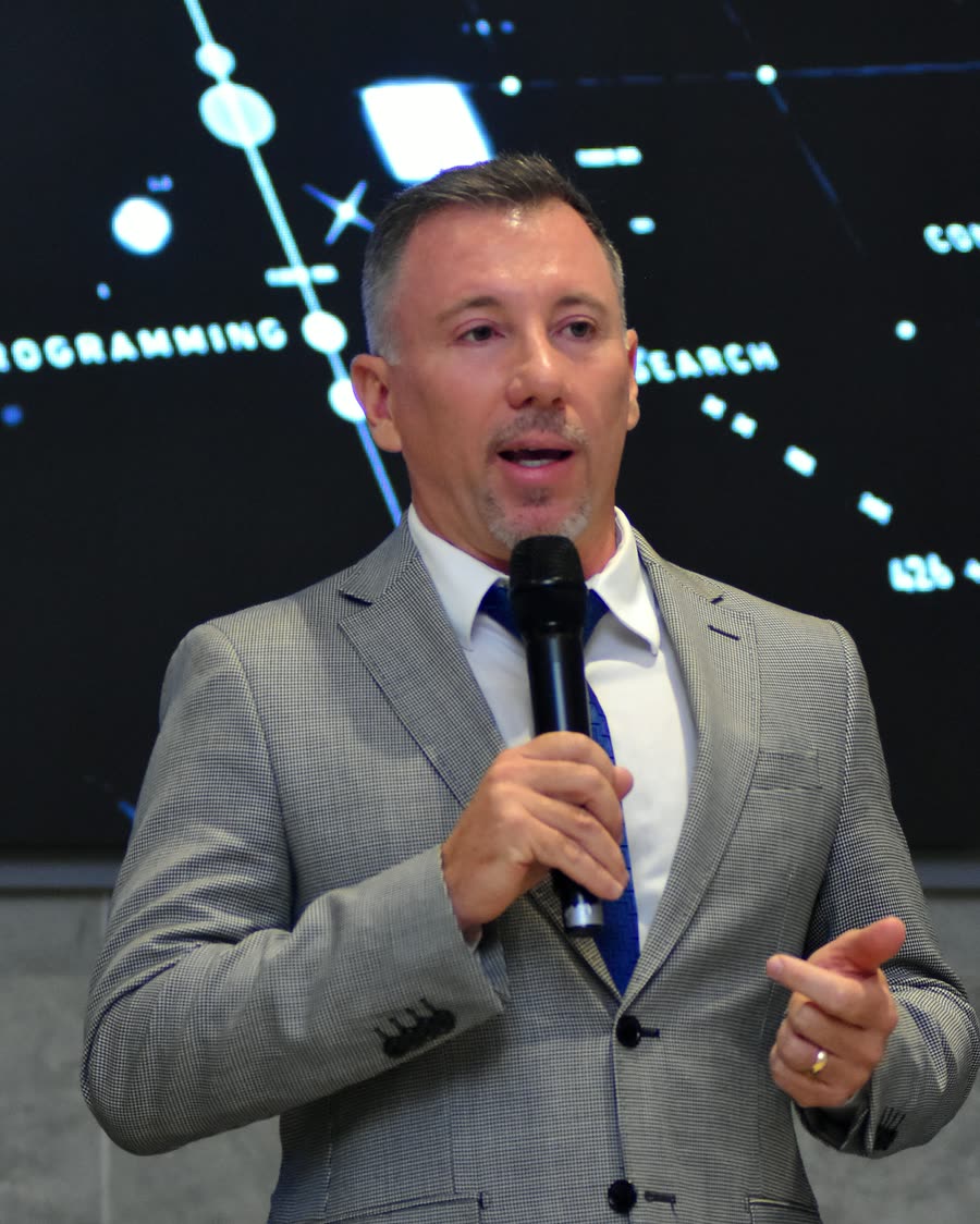 Dr. Anderson Macohin fala ao microfone no palco, em 10 de janeiro de 2024.